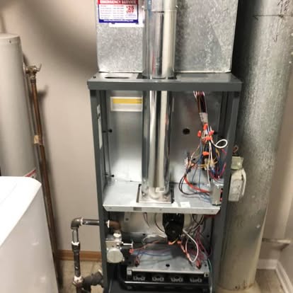 The interior of a furnace during service, showing the blower and wiring.